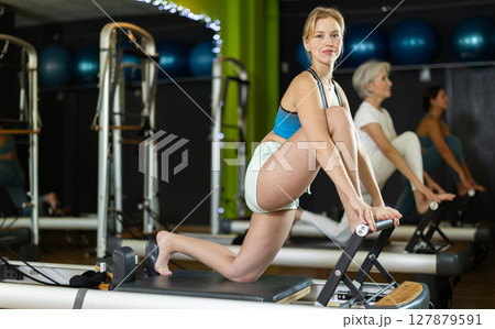 Athletic woman doing leg exercises on reformer Athletic woman doing leg exercises on reformer 127879591