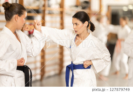 Women train to perform defensive karate installations and attacking combat techniques 127879749