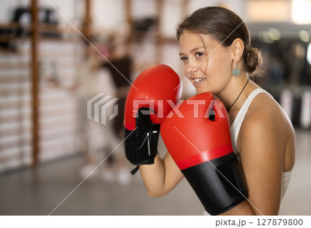 Young girl posing with boxing gloves Young girl posing with boxing gloves 127879800