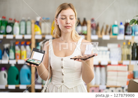 Young woman in summer clothes choosing cosmetics in supermarket Young woman in summer clothes choosing cosmetics in supermarket 127879900