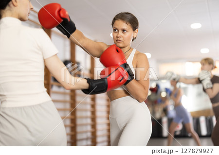 Women fight with hands, using all strength, courage during boxing lesson 127879927