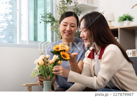 Mother and Daughter Creating Floral Arrangements Together. A Moment of Joy and Creativity. Mother and Daughter Creating Floral Arrangements Together. A Moment of Joy and Creativity. 127879987