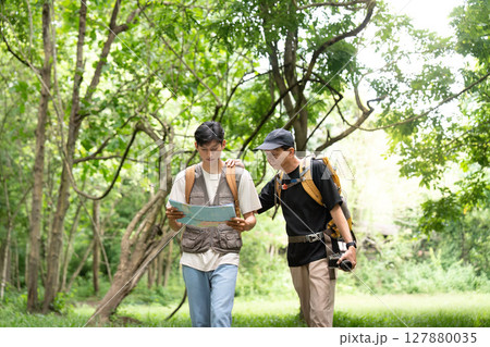 Father and Son Hiking Journey. Navigating through the forest with a map. 127880035