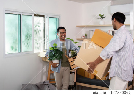 Gay couple moving in together, sharing joy and plants in their new home 127880067