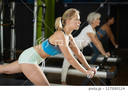 blonde woman performs exercises for the glutes and legs 127880124