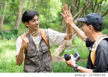 Father and Son Celebrating Hiking Success with a High Five Father and Son Celebrating Hiking Success with a High Five 127880126