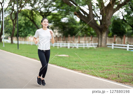 Joyful Jogging. Young woman running happily in park. Joyful Jogging. Young woman running happily in park. 127880198