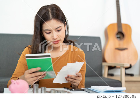 Financial Organization and Planning. Woman reviewing financial documents and savings. 127880308