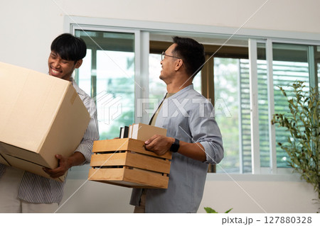Gay couple moving in together, sharing joyful moments while unpacking boxes 127880328