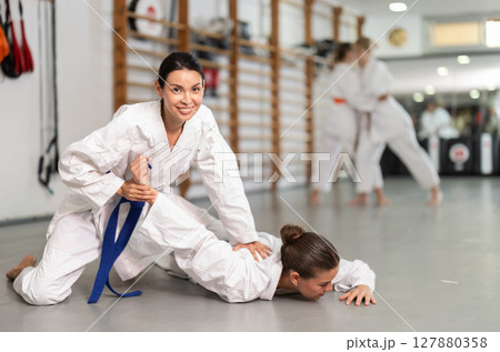 Women athletes in pair conduct training battle in oriental fighting technique judo Women athletes in pair conduct training battle in oriental fighting technique judo 127880358