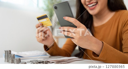 Financial Empowerment. Young woman managing personal finances with smartphone and credit card. Financial Empowerment. Young woman managing personal finances with smartphone and credit card. 127880365