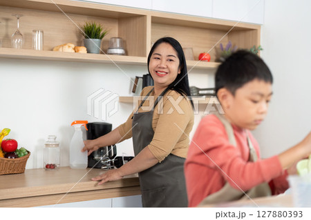 Kitchen Cleaning Collaboration. An adult and child working together in the kitchen. 127880393