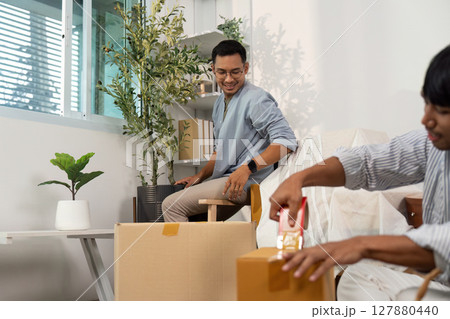 Gay couple organizing their new home with care and laughter Gay couple organizing their new home with care and laughter 127880440