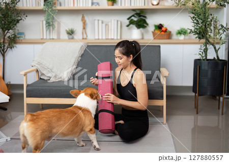 Yoga and Pet Bonding. Woman practicing yoga with her corgi dog at home. Yoga and Pet Bonding. Woman practicing yoga with her corgi dog at home. 127880557
