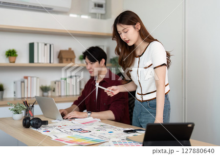 Design Collaboration. Young woman and man discussing UX UI concepts in a modern office. Design Collaboration. Young woman and man discussing UX UI concepts in a modern office. 127880640
