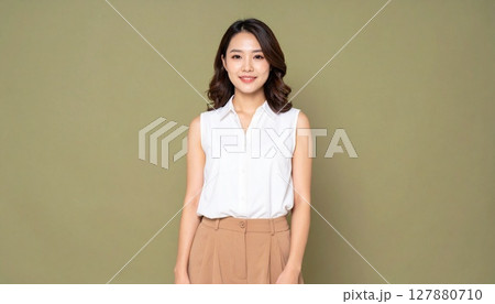 オリーブ背景で微笑むオフィスカジュアル女性 オリーブ背景で微笑むオフィスカジュアル女性 127880710