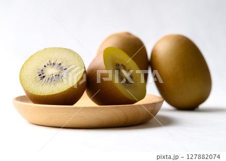 Fresh sungold kiwi fruit with wooden plate on white background, Healthy fruit 127882074