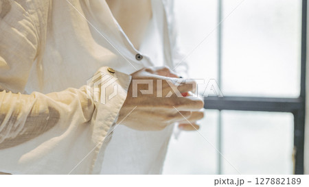 濡れたシャツを脱ぐ男性の手元 ボタン 脱衣 濡れたシャツを脱ぐ男性の手元 ボタン 脱衣 127882189