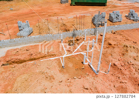 Workers are laying foundation, installing plumbing pipes at building site on works day. Workers are laying foundation, installing plumbing pipes at building site on works day. 127882784
