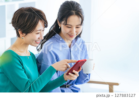 モダンなリビングでスマホを見る二人の女性 モダンなリビングでスマホを見る二人の女性 127883127