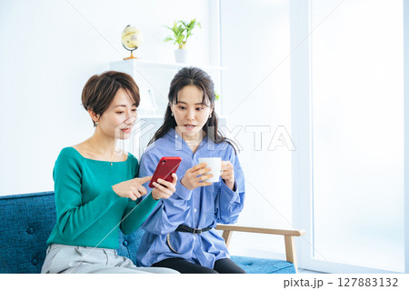 モダンなリビングでスマホを見る二人の女性 モダンなリビングでスマホを見る二人の女性 127883132