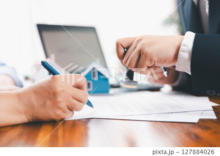 Bank approve loan to buy home concept. Real estate agent talked about terms of home purchase agreement, asked customer to sign documents to make contract legally. approved mortgage application form. Bank approve loan to buy home concept. Real estate agent talked about terms of home purchase agreement, asked customer to sign documents to make contract legally. approved mortgage application form. 127884026