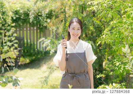 庭に立つエプロン姿の女性 庭に立つエプロン姿の女性 127884168