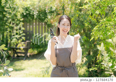 庭に立つエプロン姿の女性 127884170