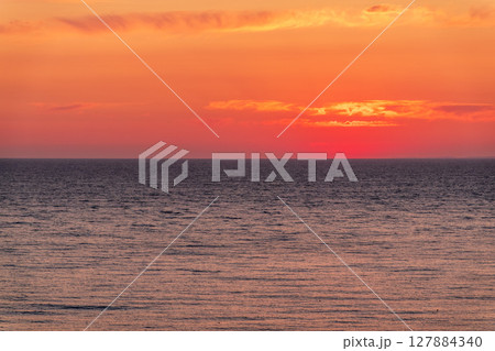 Beautiful red and orange sunrise over the sea. Beautiful red and orange sunrise over the sea. 127884340