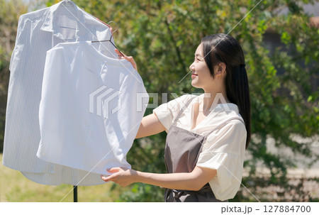 洗濯物を干す女性 127884700