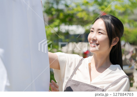 洗濯物を干す女性 127884703
