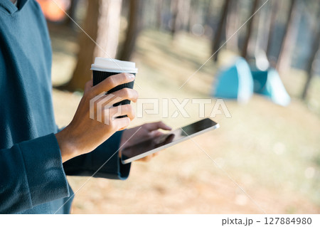 Remote work technology online close up communication smart phone laptop telephone digital travel brown nature sunlight camp beverage morning sit drink coffee tent orange outlying concept background. Remote work technology online close up communication smart phone laptop telephone digital travel brown nature sunlight camp beverage morning sit drink coffee tent orange outlying concept background. 127884980