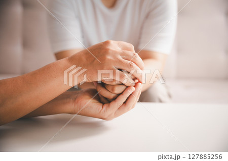 Hope and trust with crisis concept. Closeup, love and holding hands for support, comfort and care with grief, loss and empathy. people and family with compassion, sympathy and healing with bonding. 127885256