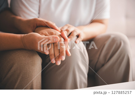 Hope and trust with crisis concept. Closeup, love and holding hands for support, comfort and care with grief, loss and empathy. people and family with compassion, sympathy and healing with bonding. Hope and trust with crisis concept. Closeup, love and holding hands for support, comfort and care with grief, loss and empathy. people and family with compassion, sympathy and healing with bonding. 127885257