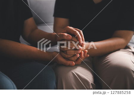 Hope and trust with crisis concept. Closeup, love and holding hands for support, comfort and care with grief, loss and empathy. people and family with compassion, sympathy and healing with bonding. Hope and trust with crisis concept. Closeup, love and holding hands for support, comfort and care with grief, loss and empathy. people and family with compassion, sympathy and healing with bonding. 127885258