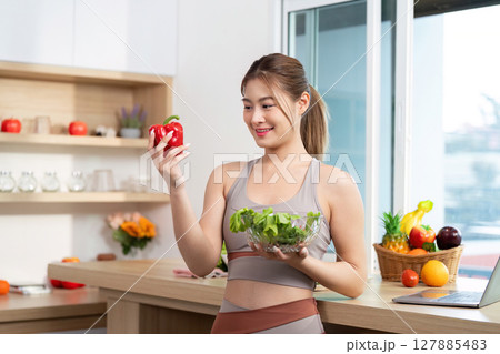 Wellness and Nutrition. Woman choosing fresh red bell pepper for healthy meal. 127885483
