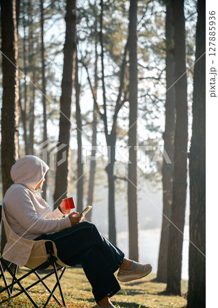 Remote work technology online close up communication smart phone laptop telephone digital travel brown nature sunlight camp beverage morning sit drink coffee tent orange outlying concept background. 127885936