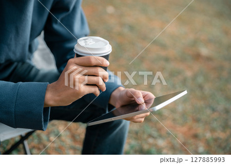 Remote work technology online close up communication smart phone laptop telephone digital travel brown nature sunlight camp beverage morning sit drink coffee tent orange outlying concept background. Remote work technology online close up communication smart phone laptop telephone digital travel brown nature sunlight camp beverage morning sit drink coffee tent orange outlying concept background. 127885993