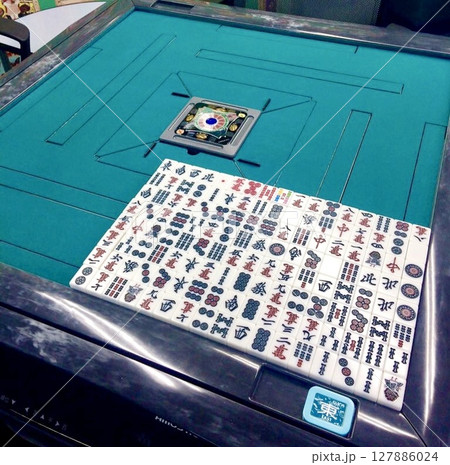 緑のラシャの麻雀卓に並ぶ麻雀牌 127886024