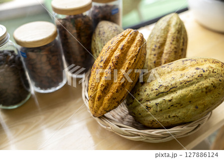 Cocoa beans and cocoa pod on a wooden surface. 127886124