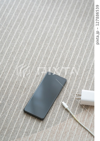 スマホとACアダプターを床に置いた構図 スマホとACアダプターを床に置いた構図 127886539