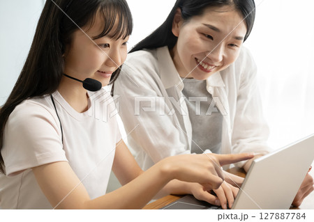 ノートパソコンを使う母娘 127887784