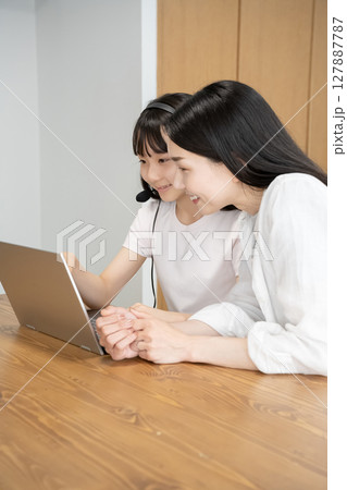 ノートパソコンを使う母娘 127887787