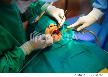 Dentist at work or Concentrated specialist removing tooth stone from client's teeth using ultrasonic scaler. Professional painless teeth cleaning at modern dental Dentist at work or Concentrated specialist removing tooth stone from client's teeth using ultrasonic scaler. Professional painless teeth cleaning at modern dental 127887858