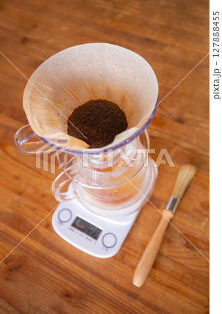 【日本】木製テーブルの上でコーヒーをハンドドリップしているところ 127888455