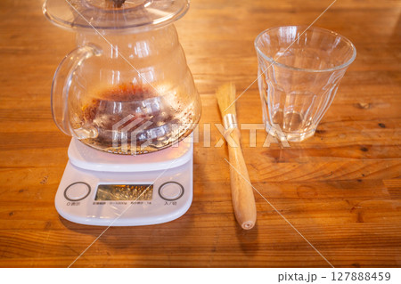 【日本】木目のテーブル上に置かれた計り、コーヒーサーバー、ガラスコップ、刷毛 【日本】木目のテーブル上に置かれた計り、コーヒーサーバー、ガラスコップ、刷毛 127888459