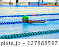Swimmer child swims butterfly swimming style in a race swimming pool. Water sports and competition, learning to swim classes for children. 127888597