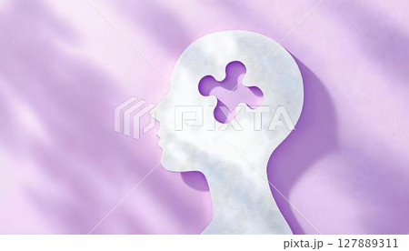 A white silhouette of a human head with an absent puzzle piece, highlighting the complexities of mental health and the journey of self-exploration 127889311