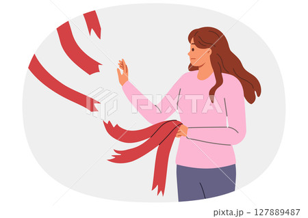 Woman breaking old ties in form of ribbons hanging from above, for concept of ending relationship 127889487