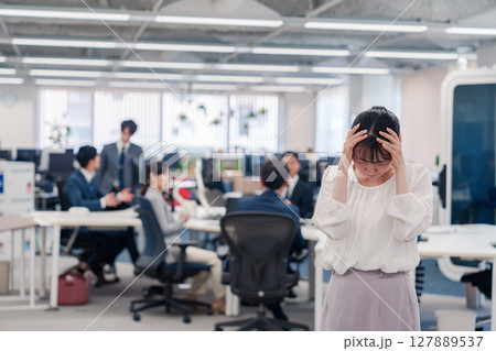 オフィスで頭を抱える女性従業員 127889537